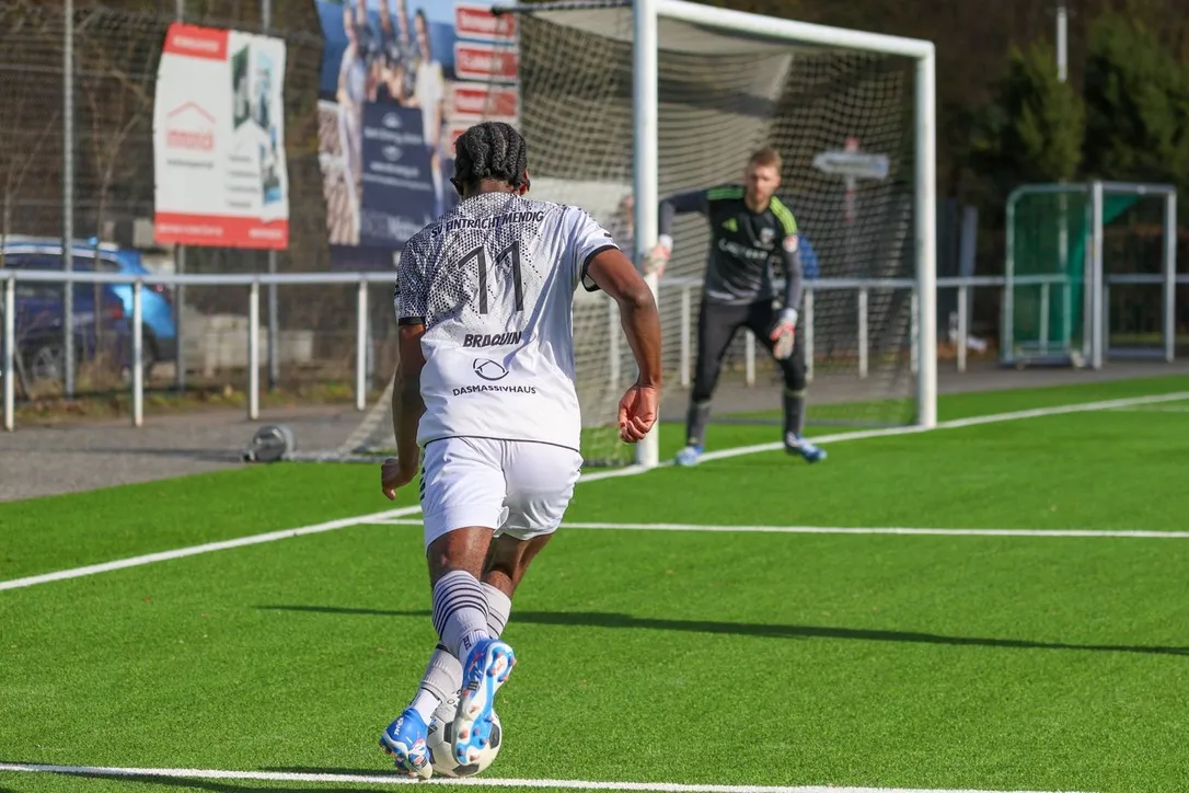 Brice Braquin, number 11 for SVE Mendig, dribbling toward the goalkeeper